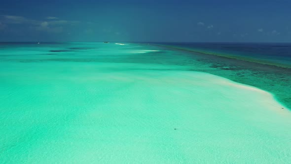 Natural flying tourism shot of a sandy white paradise beach and blue sea background in colourful 4K