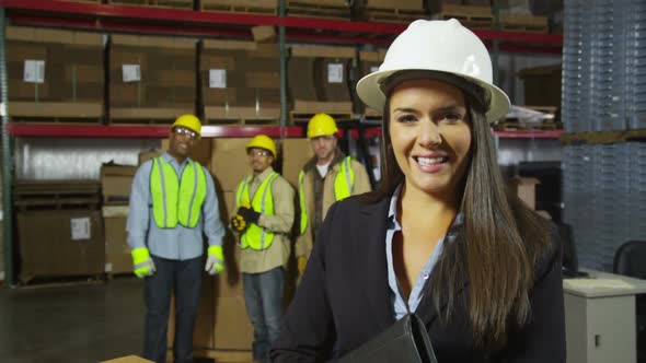 Portrait of businesswoman with workers in background