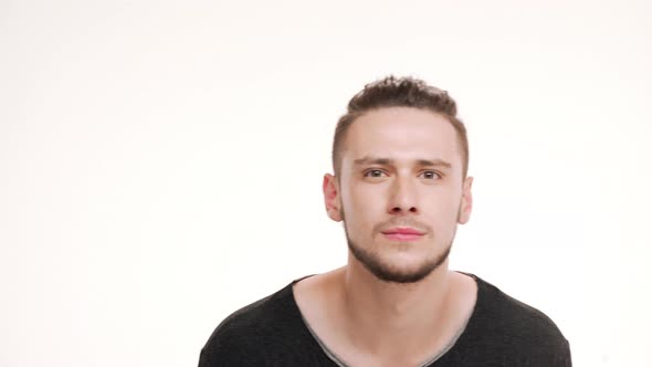 Portrait of Young Handsome Man Looking in Mirror and Checking Shaving