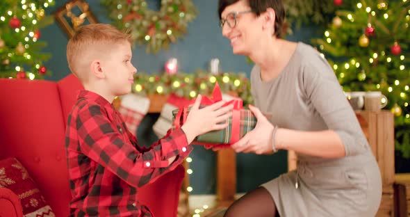 Mother is hugging her son after giving him his Christmas present