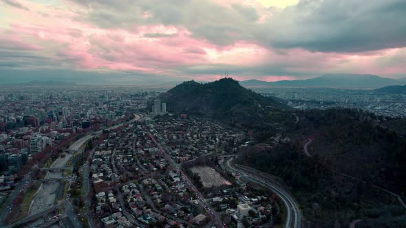 Aerial orbit of Met Park in a cloudy sunset after rain, mountainous horizon.