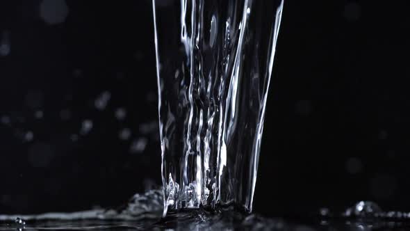 Pouring water on black background, Slow Motion