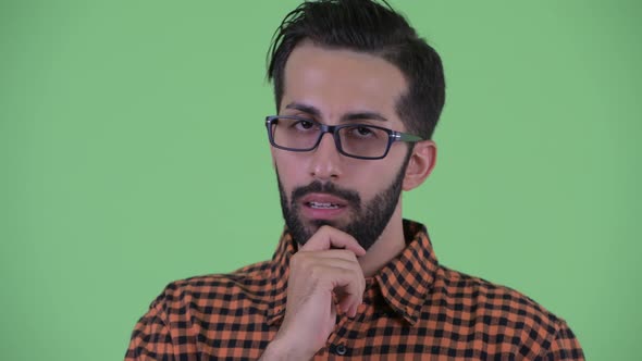 Face of Stressed Young Bearded Persian Hipster Man Thinking and Looking Down