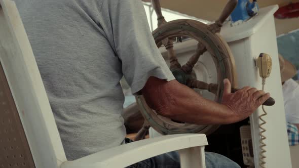 Fisherman Sailing On Sea And Looking Place For Fishing. Close Up Steering Wheel On Sea Trips.