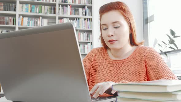 Female Student Using Her Laptop at College Library