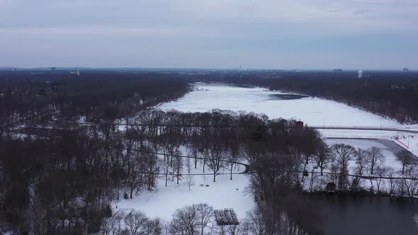 An aerial view from a drone, over a frozen lake during a cloudy sunrise. The camera dolly in over th