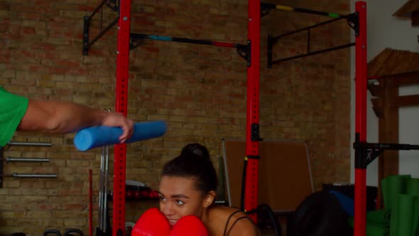 Active Sporty African Female Fighter in Boxing Gloves Exercising with Trainer