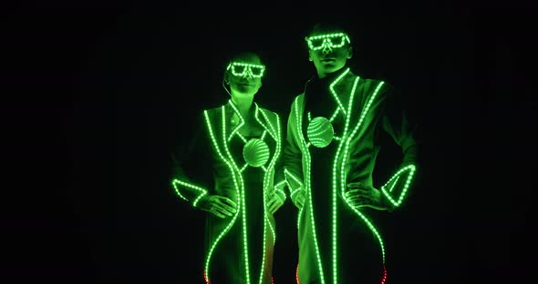 Colorful Lights All Over the Costumes of Two Performers in the Dark Film Grain