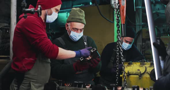 Male Mechanics in Masks Repairing Engine