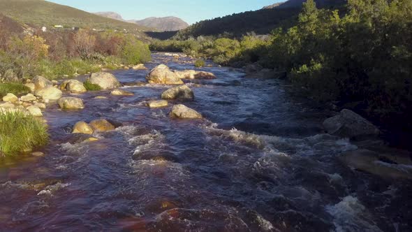 Aerial over a mountain stream in the countryside