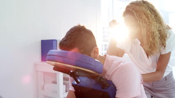 Female physiotherapist giving back massage to a male patient