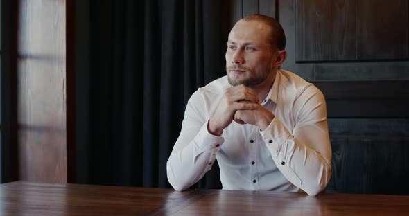 Man Sitting at a Table Alone Waiting for Someone