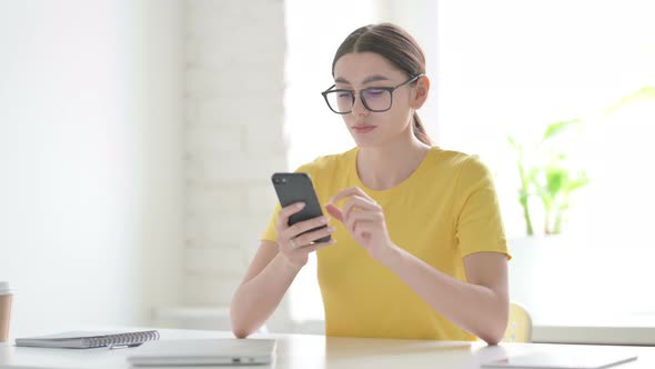 Woman Browsing Internet on Smartphone in Office