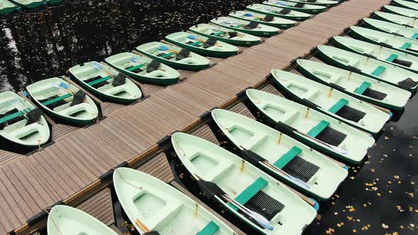 Boats on Wooden Pier on River Reflecting Sky in Autumn Park