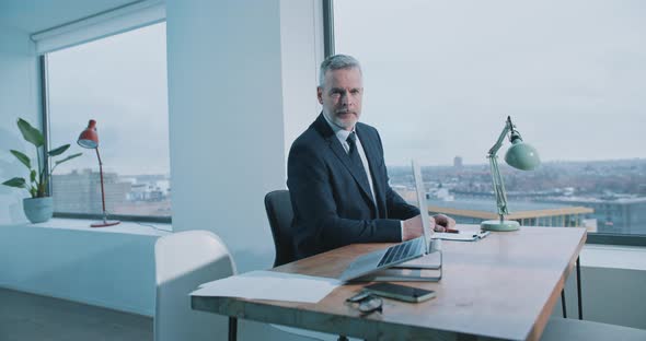 Man sits at desk and looks toward door