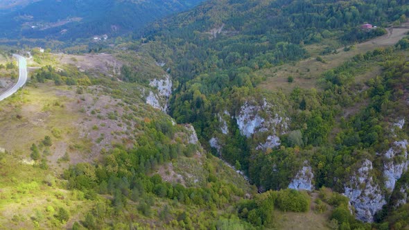 Steep green mountains, deep forest and mountain road, beautiful valley  