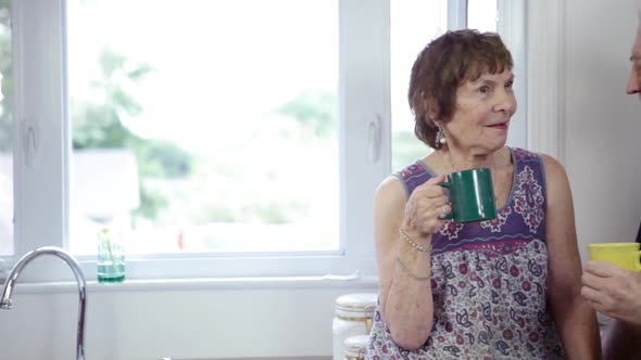 Senior couple having hot drinks and talking