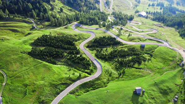 Aerial view of winding road at green Passo Gardena, Dolomites