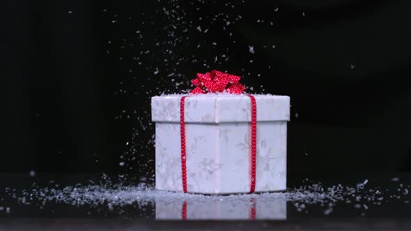 Glitter falling onto christmas present in slow motion