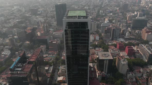 Fly Over Tall Office Building Tilt Down to Shot of Heliport on Roof of Skyscraper