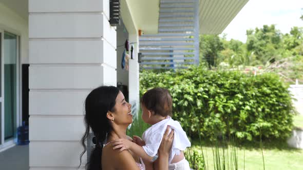 A Sweet Mother Gently Lifts Her Son Up with Her Hands