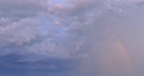 During a Severe Thunderstorm the Sky is Adorned with a Bright Rainbow in Contrast to the Landscape