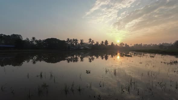 Sunrise rural area of Malay village at Penang, Malaysia in reflection.