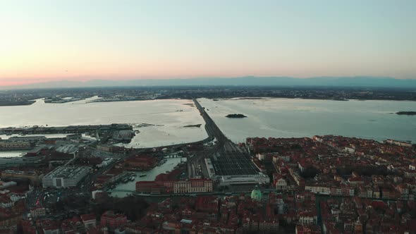 Dolly forward drone shot of Venice Santa Lucia train station towards Mestre at sunset