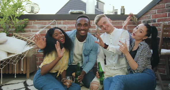 Attractive Carefree in Good Mood Diverse Youth which Sitting on the Carpet on Balcony