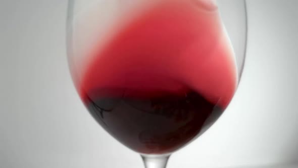 Slow Motion Shot of Red Wine Being Swirled Around Glass