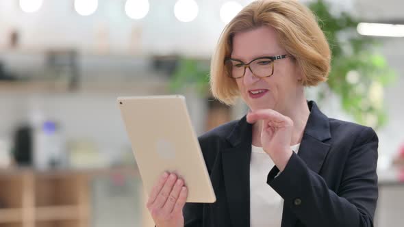 Portrait of Old Businesswoman Doing Video Call on Digital Tablet 