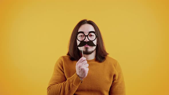 Funny Slowmo of Handsome Man with Fake Mustache on Color Background