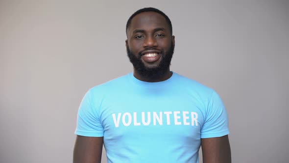 Afro-American Volunteer Showing Charity Gift Box at Camera Present for Poor Kids