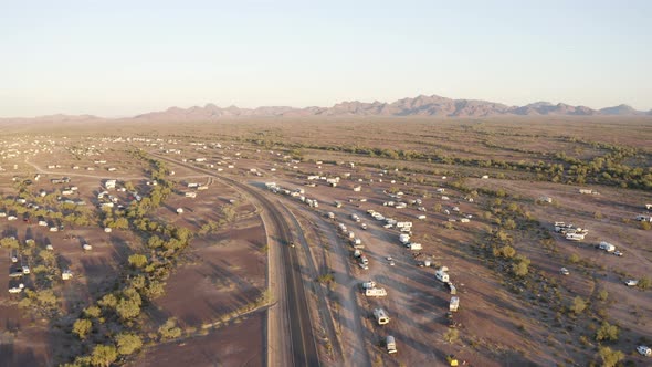 Aerial pull-back over long desert shadows at dusk