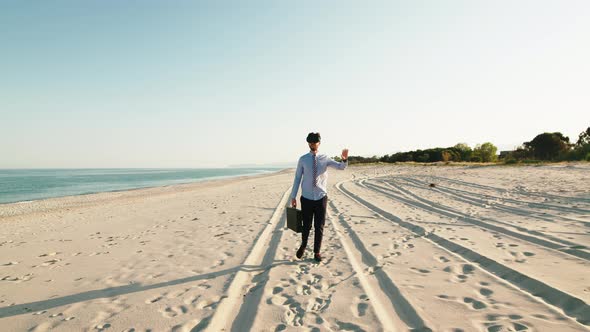 Business Guy Walks at the Beach with Virtual Reality Glasses