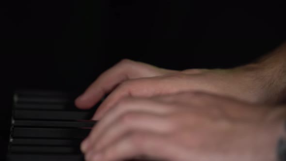 Male Hands Playing on Synthesizer Piano Keyboard in Dark Studio. Performance Vocal and Musical Band