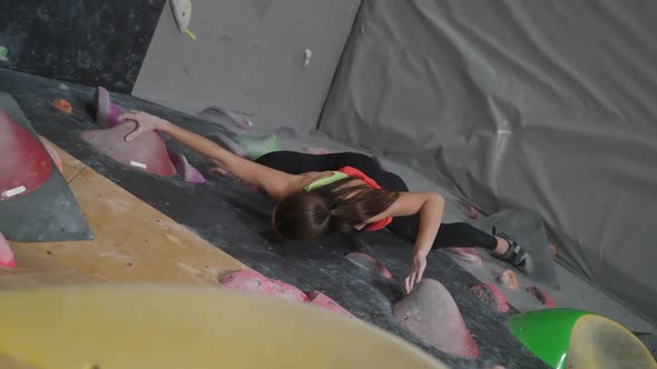 Female Climber Training on a Climbing Wall Young Woman Practicing Rockclimbing Mountaineer Training