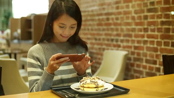 Woman taking photo with her cake before eating