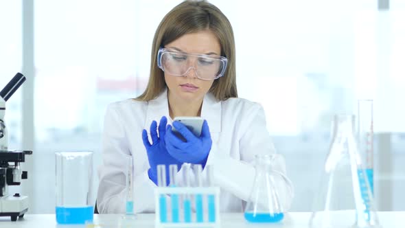 Female Scientist Holding Test Tube with blue Solution