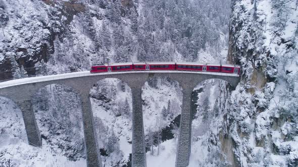 Landwasser Viaduct with Railway and Train in Winter. Snowing. Swiss Alps. Switzerland. Aerial View