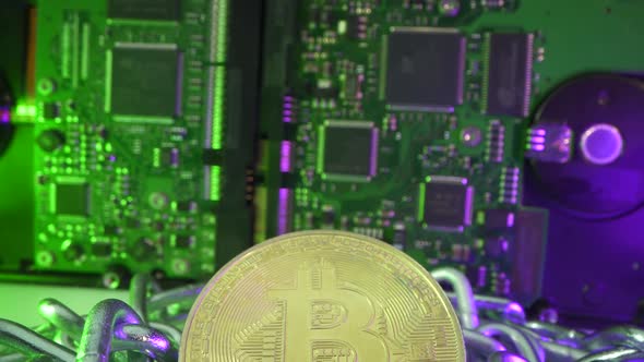 Gold Bitcoin Coin in Silver Chain. Vertical Panorama. HDD on the Background. Blockchain Technology