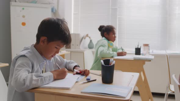 Asian Boy Taking Test in Classroom