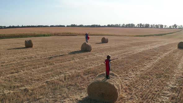 Drone Shot of Superheroes in Pose on Straw Stacks