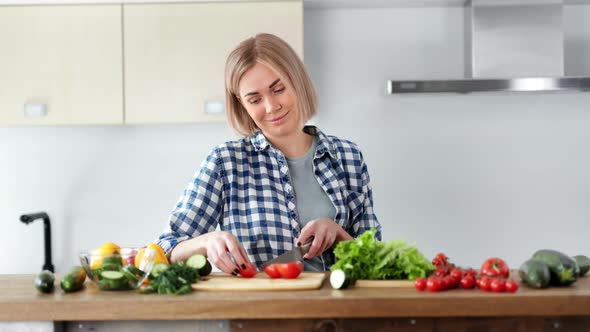 Smiling Adorable Young Woman Cooking Fresh Salad Chopping Tomato on Wooden Board Using Knife