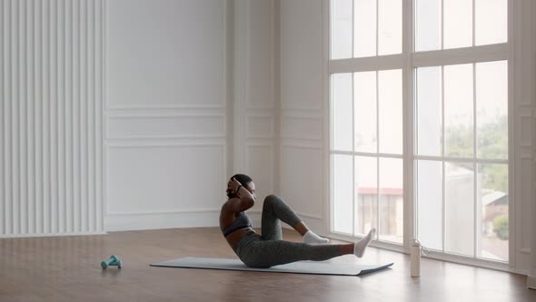 Sporty Black Woman Doing ElbowTo Knee Abs Crunches Exercise Training At Home