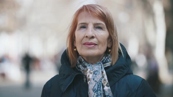 Smart Senior Woman in Stylish Scarf Standing in Airy Alley in Autumn in Slo-mo  