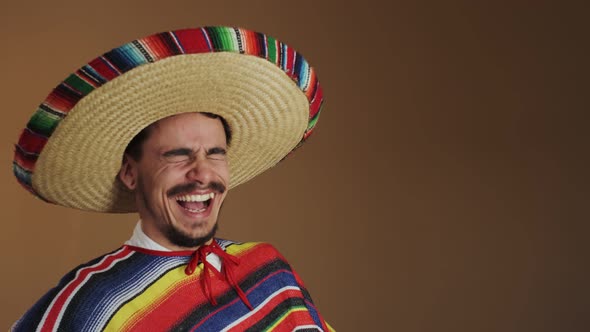 Young Mexican In Multicolored Poncho And Hat