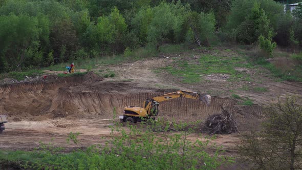 Tipelapse: yellow excavator moving trees branches.