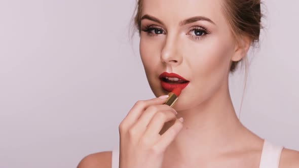 Beautiful Woman Applies Red Lipstick and Showing Heart with It