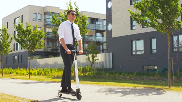 Young Businessman Riding Electric Scooter Outdoors